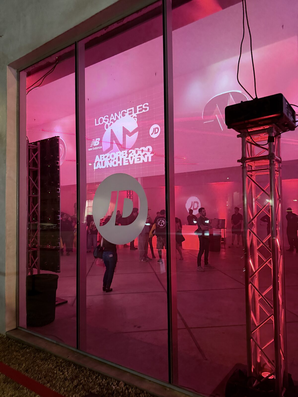 Storefront glowing pink through glass during a Los Angeles sneaker launch event at night